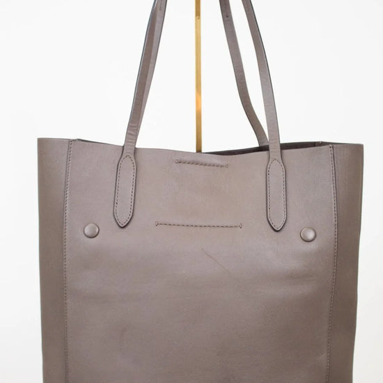 Brown tote bag with gold accents on a white background