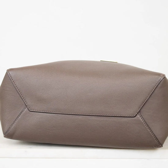 Bottom of brown leather tote on white background