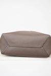 Bottom of brown leather tote on white background