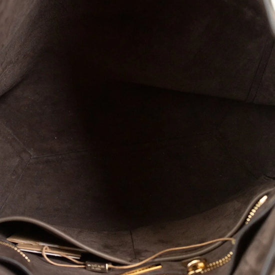 Close-up of a brown leather bag with gold zipper and hardware.