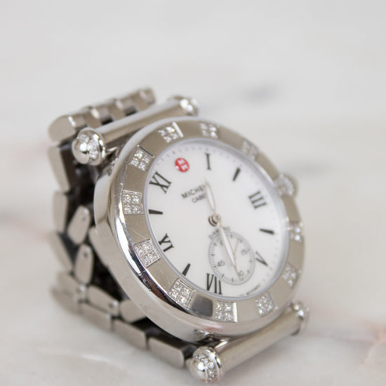 Silver watch with diamond accents on a marble surface