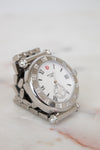 Silver watch with diamond accents on a marble surface