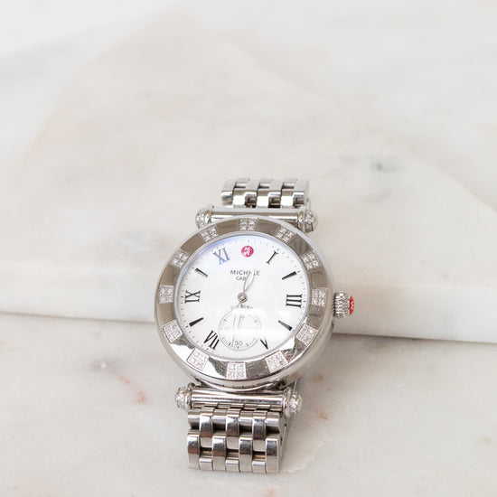 Silver watch with a white face on a marble surface