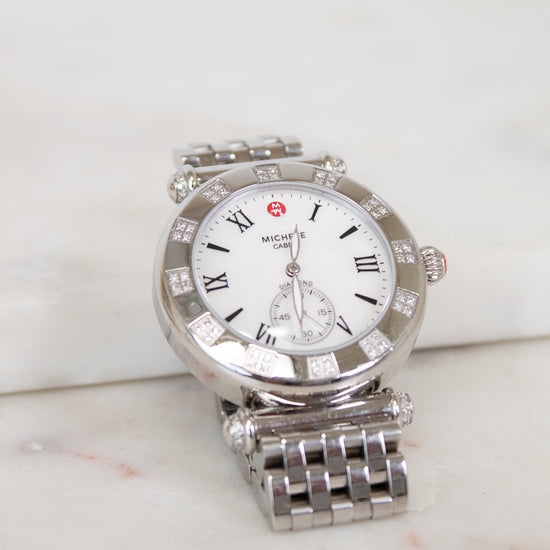 Silver watch with a white face on a light background