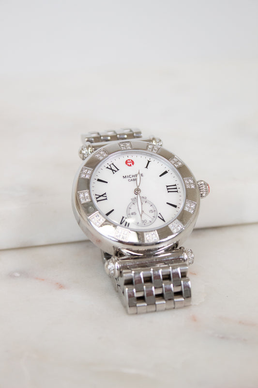 Silver watch with a white face on a light background