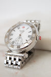Silver watch with a white face on a light background