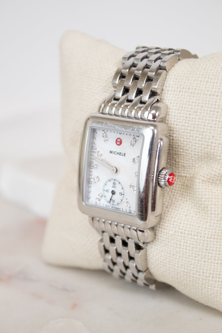 Silver Michele watch on a white cushion with a light background
