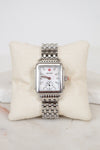 Silver watch with a detailed face on a white cushion