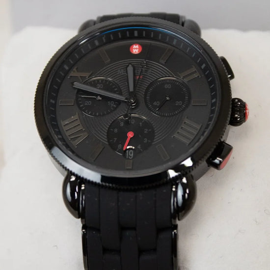 Black wristwatch with detailed face on a white cushion