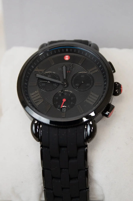 Black wristwatch with detailed face on a white cushion