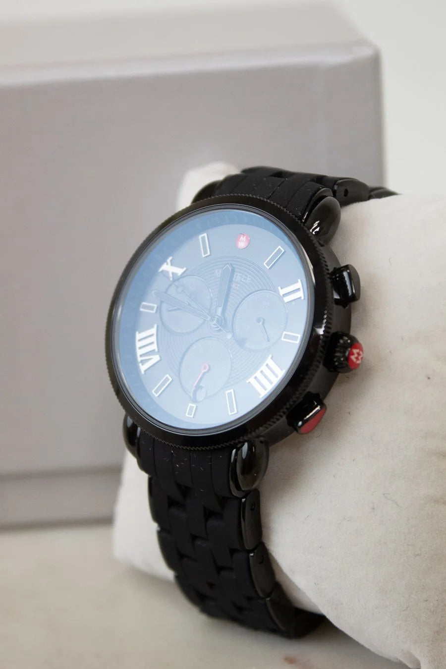 Black wristwatch on a white surface