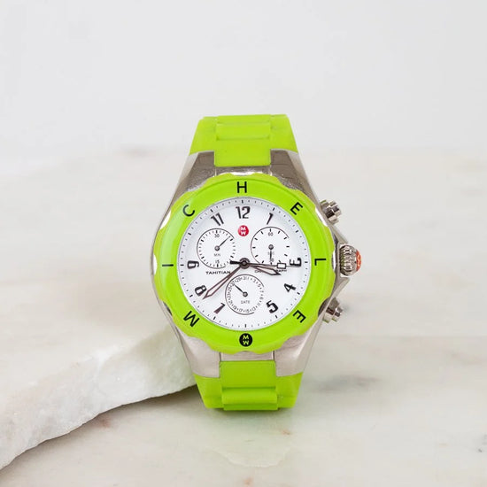 Green watch with a white face on a marble surface