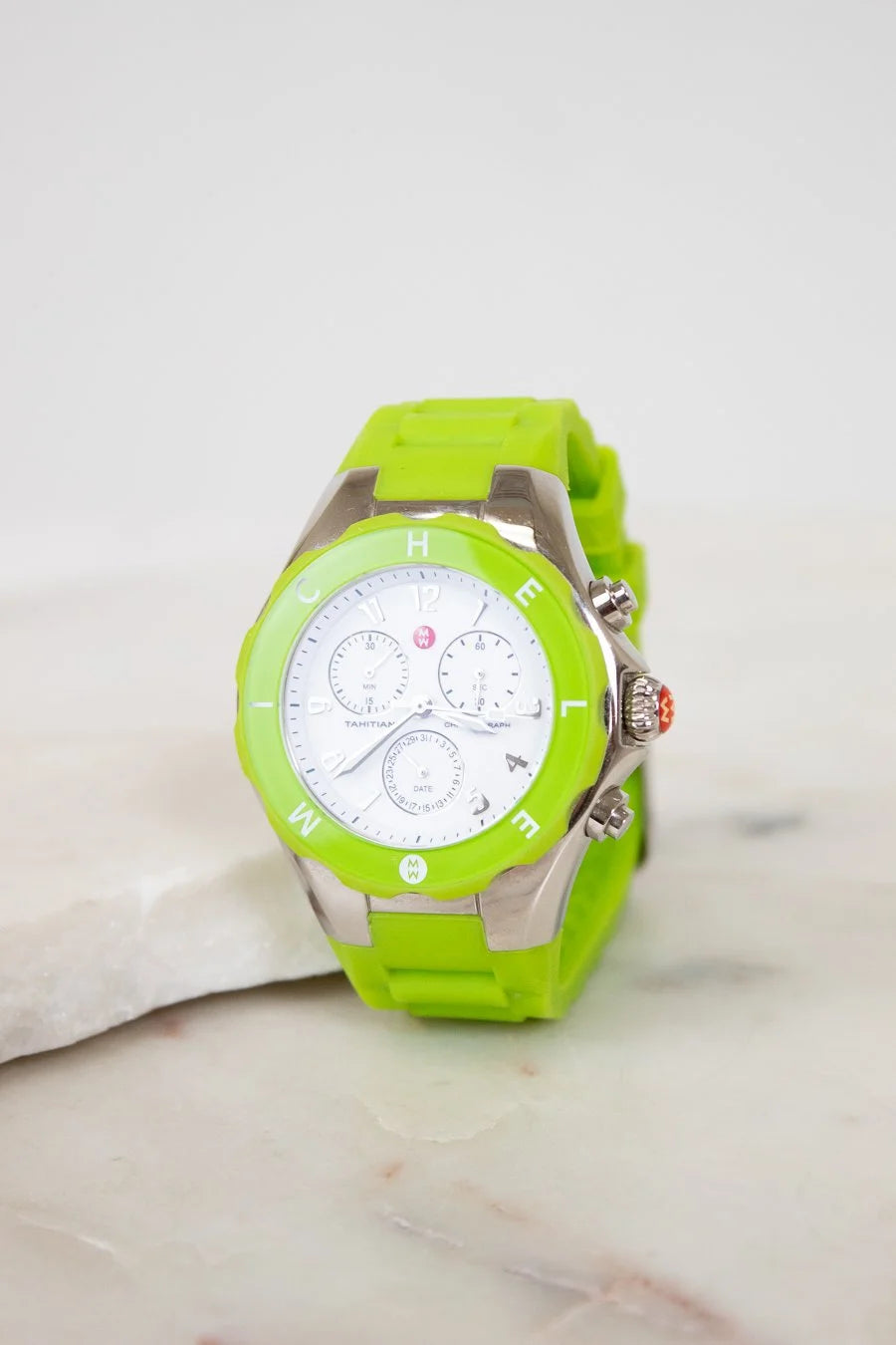 Green watch with a white face on a light background