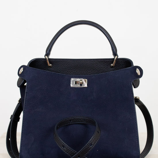 Navy blue handbag with silver-tone accents on a light gray background