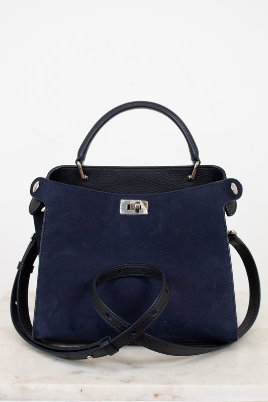Navy blue handbag with silver-tone accents on a light gray background
