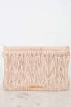 Quilted beige clutch bag with gold logo on a light gray background