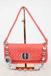 Coral handbag with decorative elements on a white background