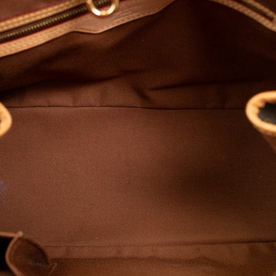 Close-up of a brown leather handbag with gold hardware.