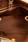 Close-up of a brown leather handbag with gold hardware.
