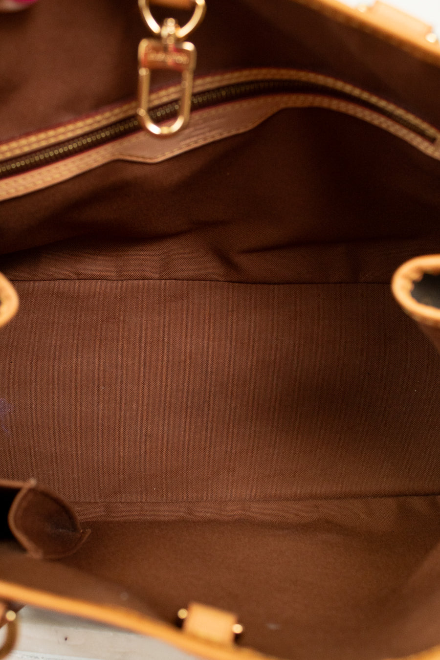 Close-up of a brown leather handbag with gold hardware.