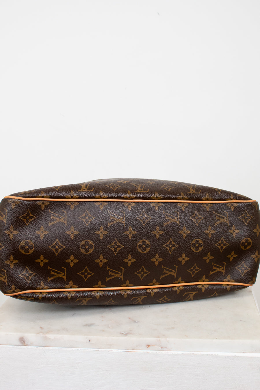 Brown Louis Vuitton monogram handbag on a white surface