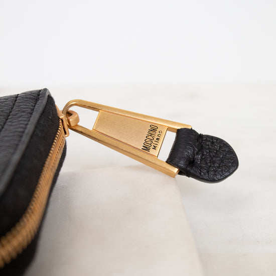 Black wallet with gold zipper on a white background