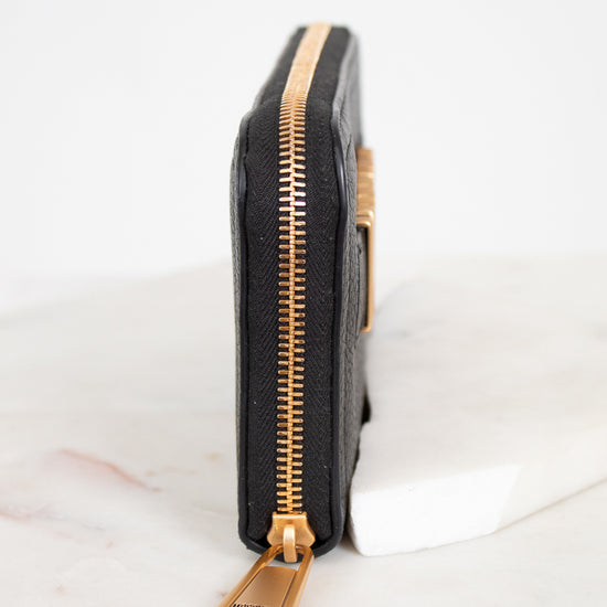 Black wallet with gold zipper on a white background