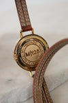 Close-up of a Movado watch with brown leather strap on a marble surface