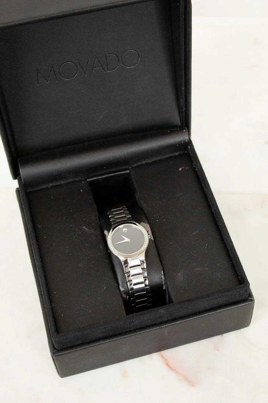 Movado watch in a black box on a light background