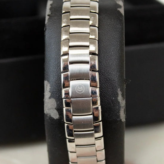 Silver bracelet on a black cushion with a blurred background