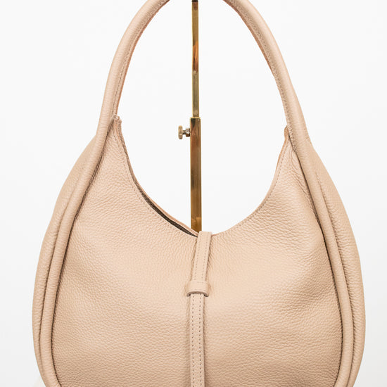 Beige handbag on a gold purse stand on a white background