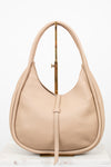 Beige handbag on a gold purse stand on a white background