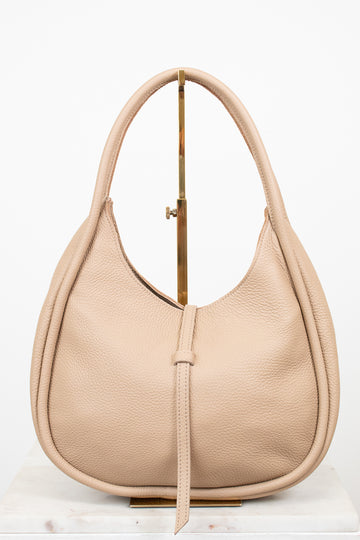 Beige handbag on a gold purse stand on a white background