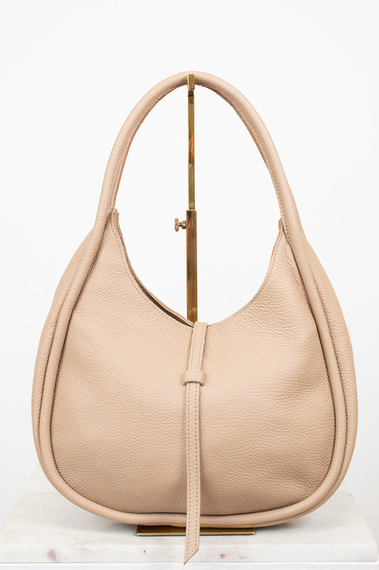 Beige handbag on a gold purse stand on a white background