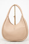 Beige handbag sitting on a gold purse stand on a white background