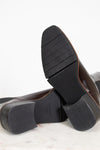 Close-up of black leather shoes with a white background