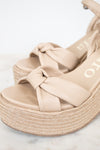 Beige sandal with woven sole on a light background
