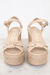 Pair of beige sandals with platform sole on a white background