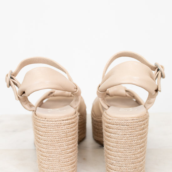 Beige sandals with woven sole on a white background