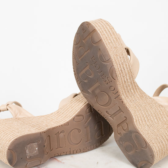 Beige sandals with textured soles on a light background