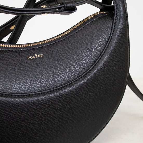 Black leather handbag with visible brand name on a light background