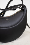 Black leather handbag with visible brand name on a light background