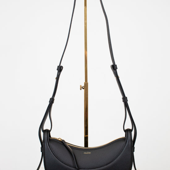 Black handbag with a gold clasp on a white background