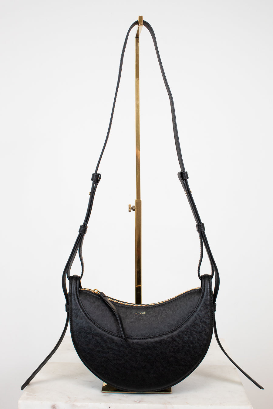 Black handbag with a gold clasp on a white background