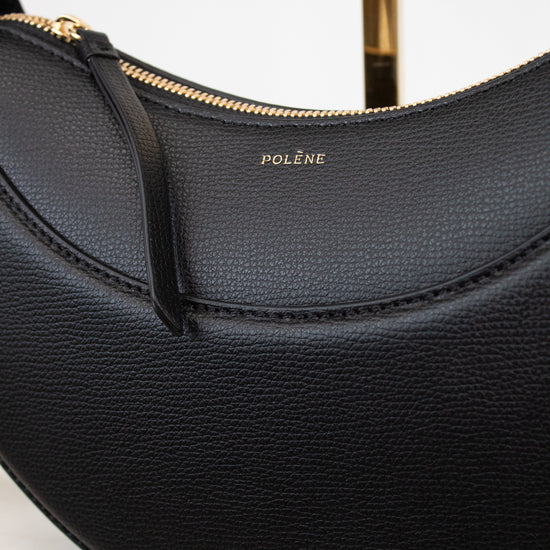 Black handbag with gold accents on a white background