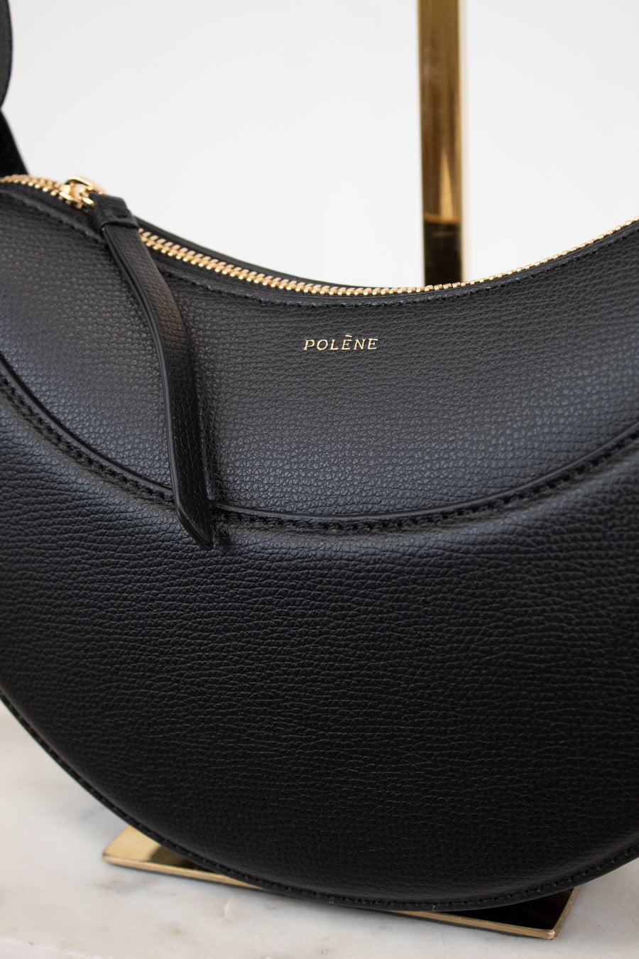 Black handbag with gold accents on a white background