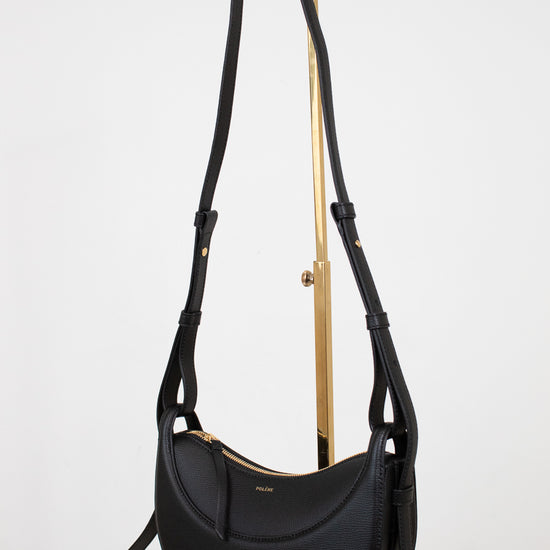 Black handbag with gold accents on a white background