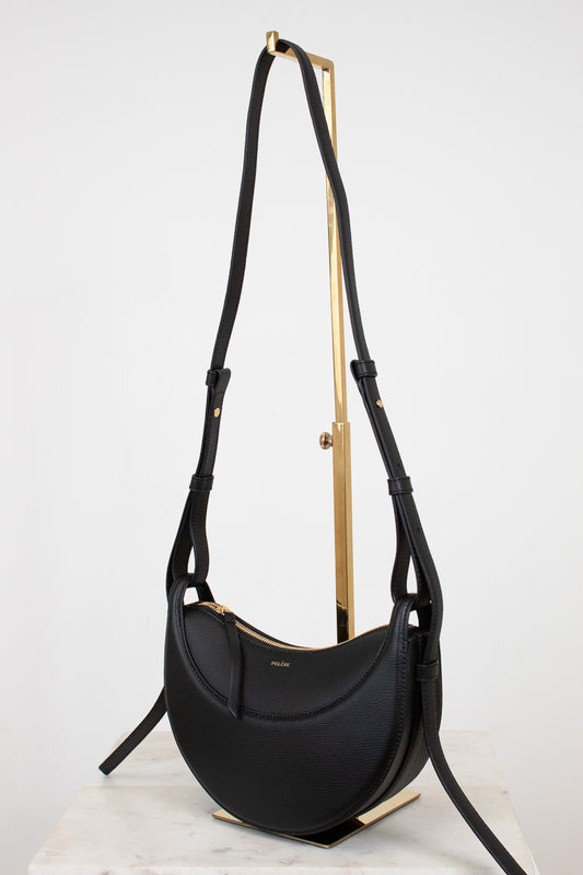 Black handbag with gold accents on a white background