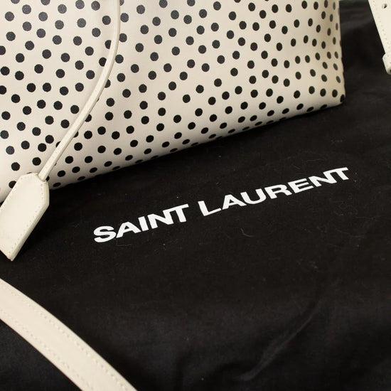 Polka dot handbag with 'Saint Laurent' logo on a black background