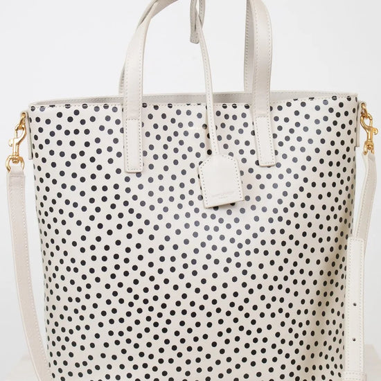 White tote bag with black polka dot pattern on a white background